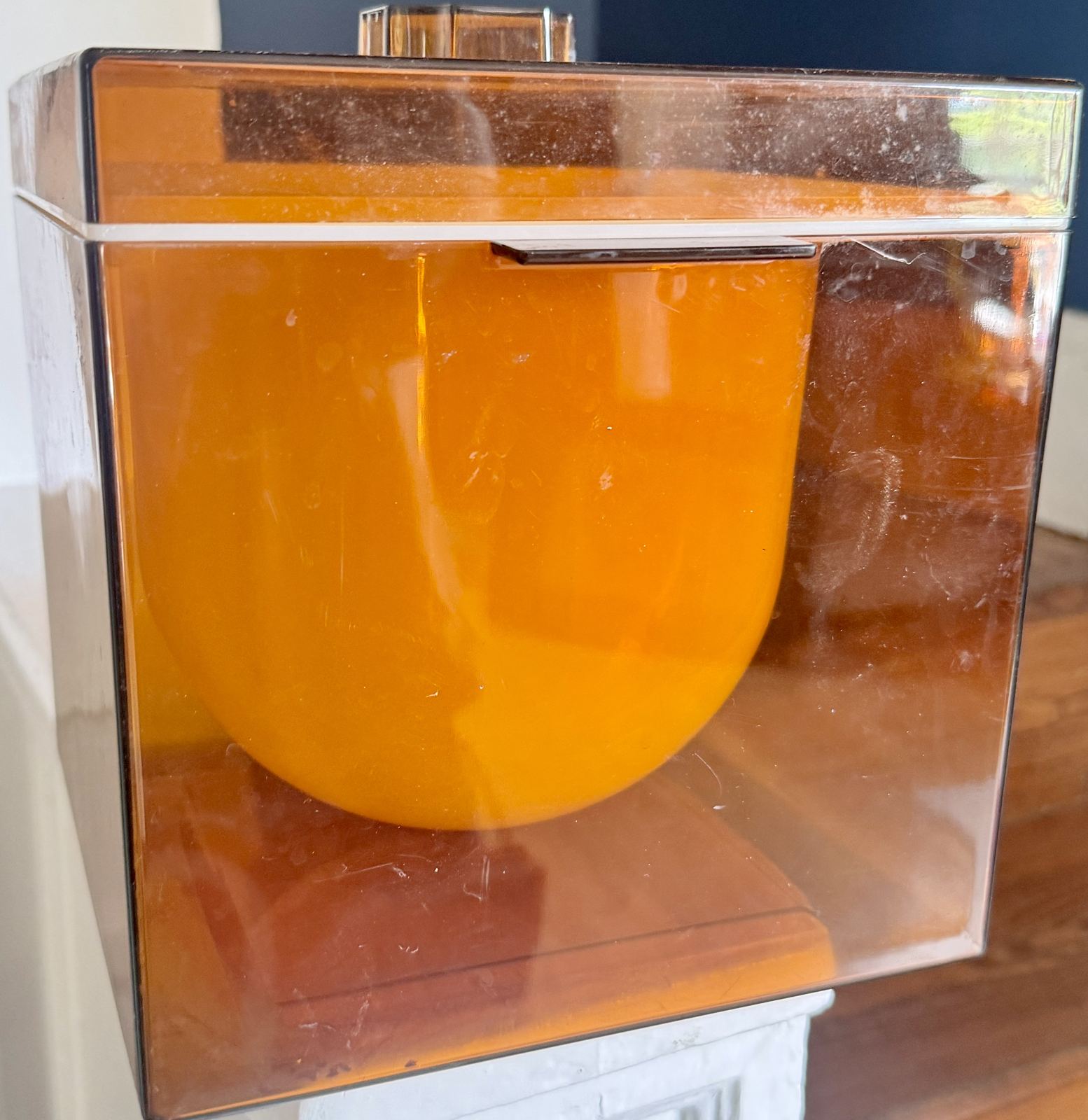 Mid-century amber lucite ice bucket in a mirrored chrome sleeve