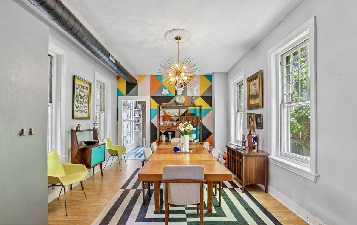 Dining room with sunburst chandelier and geometric accent wall