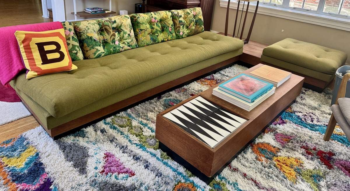 Green tufted sectional sofa with backgammon coffee table